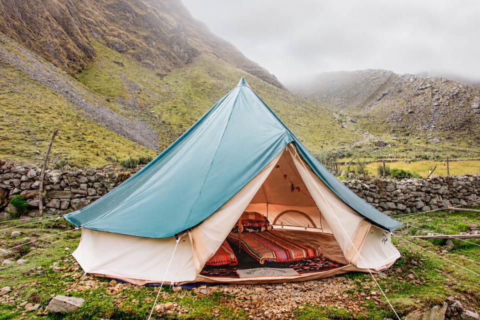 Interior de la tienda de Glamping Salkantay con dos camas y mantas coloridas | TreXperience