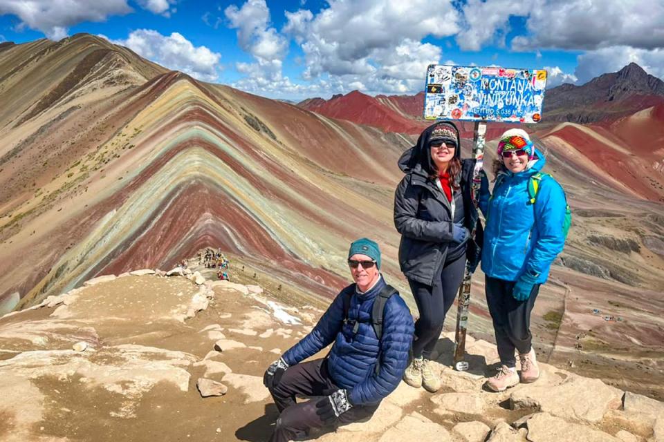 Friends next to the Vinicunca Rainbow Mountain sign | TreXperience