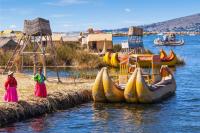 Local people of the Uros Islands in Puno smiling beside their handcrafted reed boats; part of the 20-day Peru tour.