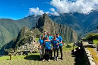 Tourists enjoying their visit to the Machu Picchu citadel under radiant sunshine, part of the Sacred Valley and Inca Trail 3 Days experience.