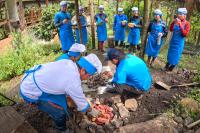 Group of people preparing pachamanca with stones in an outdoor oven | TreXperience