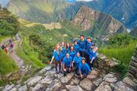 Grupo de viajeros posando con vista panorámica de Machu Picchu en el camino inca | TreXperience