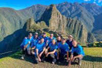 Grupo de viajeros posando con vista panorámica de Machu Picchu | TreXperience