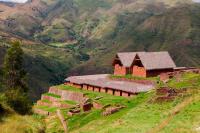 Vista de construcciones de piedra con techos de paja en Huchuy Qosqo | TreXperience