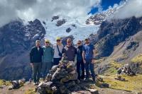 Grupo de excursionistas posando frente a una montaña nevada y un glaciar en un paisaje andino | TreXperience
