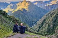 Dos viajeros sentados junto en el Inti Punku viendo a Machu Picchu | TreXperience