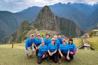 Group of travelers posing with a panoramic view of Machu Picchu | TreXperience